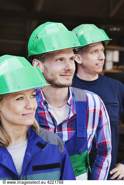 Three colleagues in green helmets