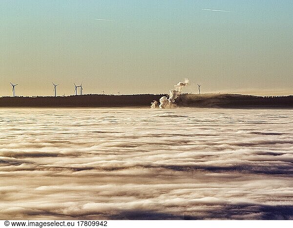 Three columns of steam rising from cloud cover  wind turbines  wind power station on the horizon  evening sun  Köterberg  Lügde  Weserbergland  North Rhine-Westphalia  Germany  Europe