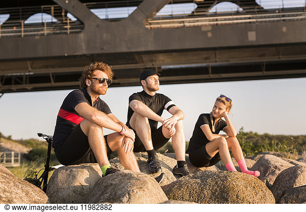 Three cyclists by bridge