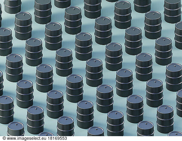 Three dimensional pattern of black oil drums standing against blue background