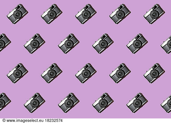 Three dimensional pattern of rows of cameras against pink background
