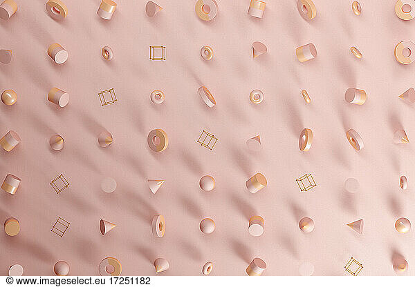 Three dimensional pattern of spheres  cones  rings  cubes and cylinders floating against pink background