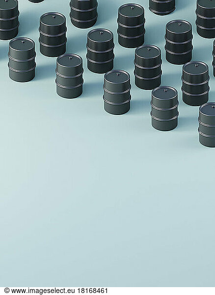 Three dimensional render of black oil drums standing against blue background
