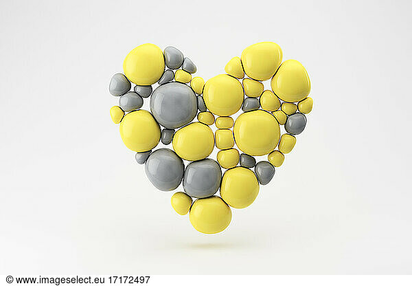 Three dimensional render of floating heart made of gray and yellow spheres
