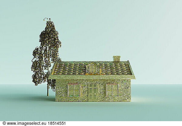 Three dimensional render of gold colored house standing against blue background