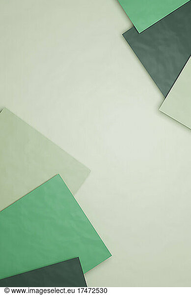 Three dimensional render of green sheets of paper against pastel green background