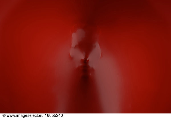 Three dimensional render of human face wrapped in red plastic foil