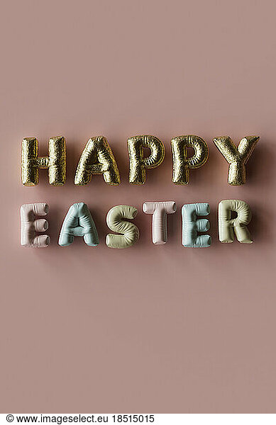 Three dimensional render of inflatable letters spelling phrase Happy Easter