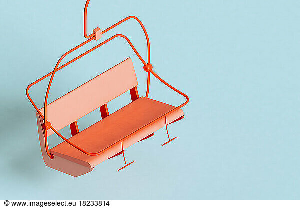 Three dimensional render of red ski lift floating against blue background