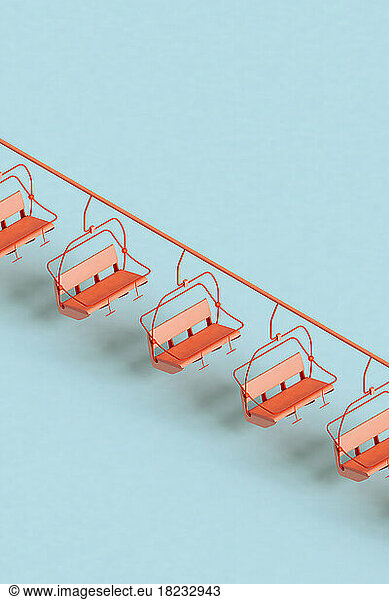 Three dimensional render of red ski lifts floating against blue background
