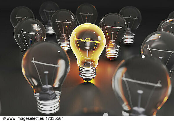 Three dimensional render of single glowing light bulb standing amid other light bulbs