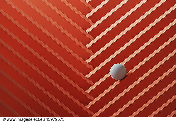 Three dimensional render of small white sphere rolling over geometric pattern