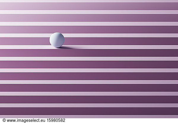 Three dimensional render of small white sphere rolling over geometric pattern