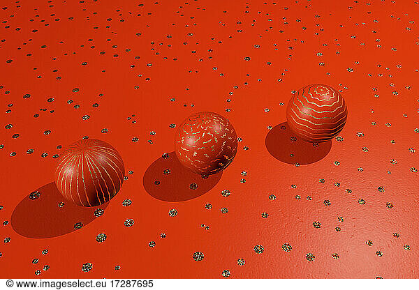 Three dimensional render of three red spheres lying against red spotted background