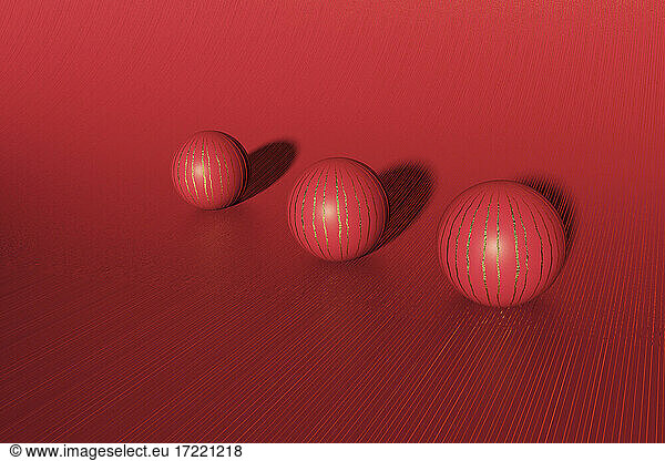 Three dimensional render of three red striped spheres lying against red background