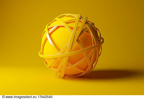 Three dimensional render of yellow sphere tangled in yellow cables