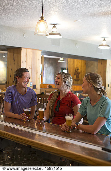 Three female friends enjoy a beer at a brewery in Government Camp  OR.