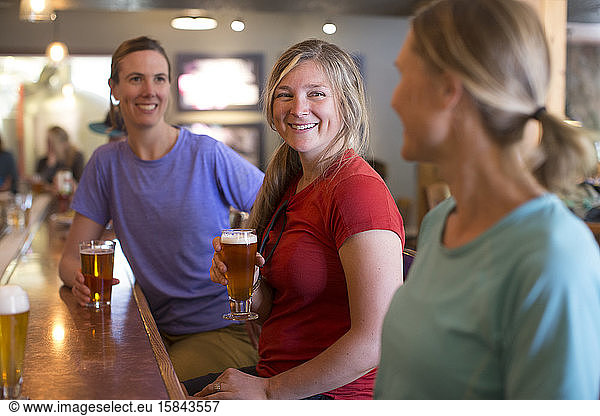 Three female friends enjoy a beer at a brewery in Government Camp  OR.
