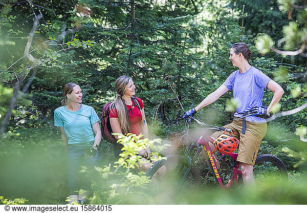 Three female friends mountain bike on a trail at Mt. Hood  Oregon.
