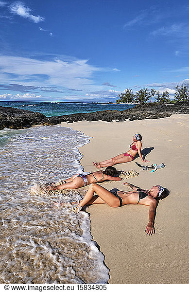 Three friends enjoying the waves and sand on Makalawena Beach  Hawaii