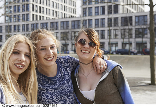 Three friends smiling in a playground  Munich  Bavaria  Germany