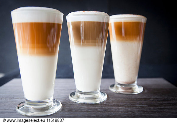 Three glasses of latte macchiato on table