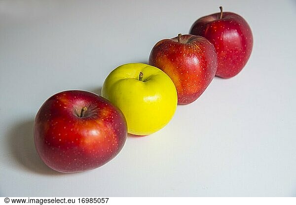 Three red apples and a green one in a row.