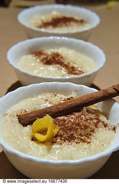 three rice pudding desserts on a brown base decorated with cinnamon a
