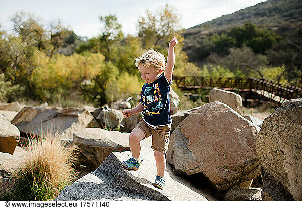 Three Year Old Boy Striking Pose on Rocks in San Diego