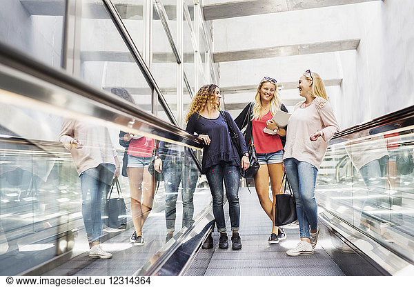 Three young women on escalator
