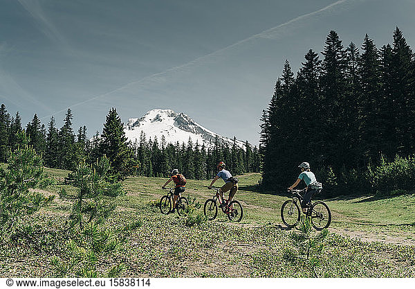 Threee women bike on a trail near Mt. Hood in Oregon.