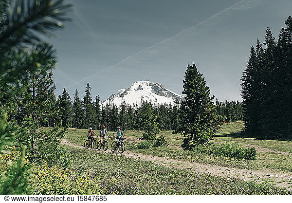Threee women bike on a trail near Mt. Hood in Oregon.