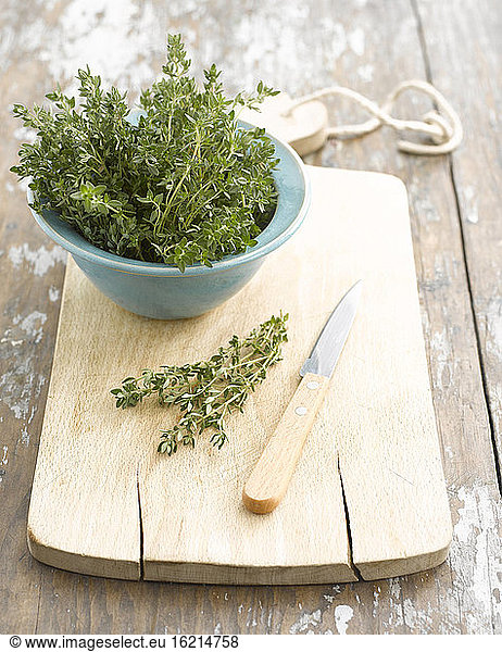 Thyme in bowl  knife and chopping board