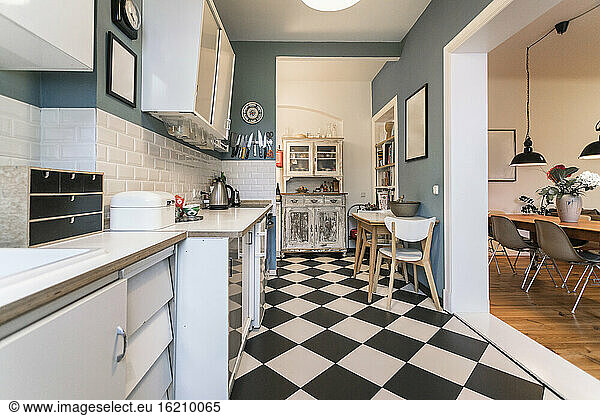 Tidy apartment kitchen with checkerboard floor