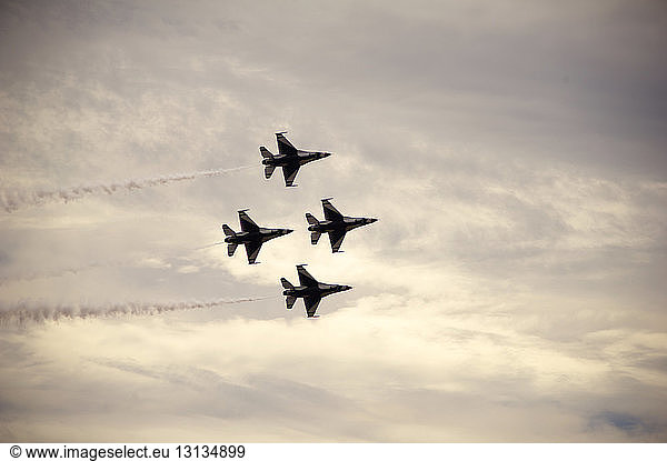 Tiefblick auf Kampfflugzeuge  die während einer Flugschau am bewölkten Himmel fliegen