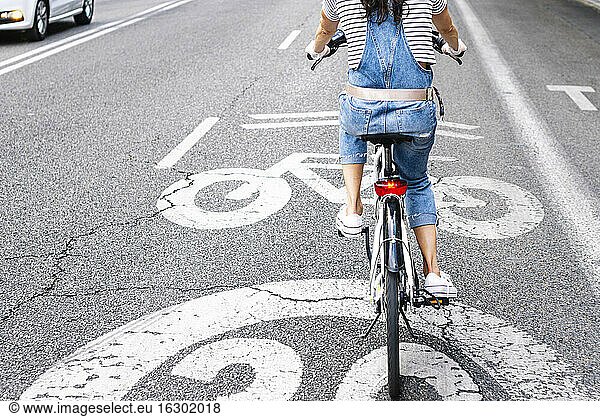 Tiefschnitt einer Frau beim Fahrradfahren auf einer Straße in der Stadt
