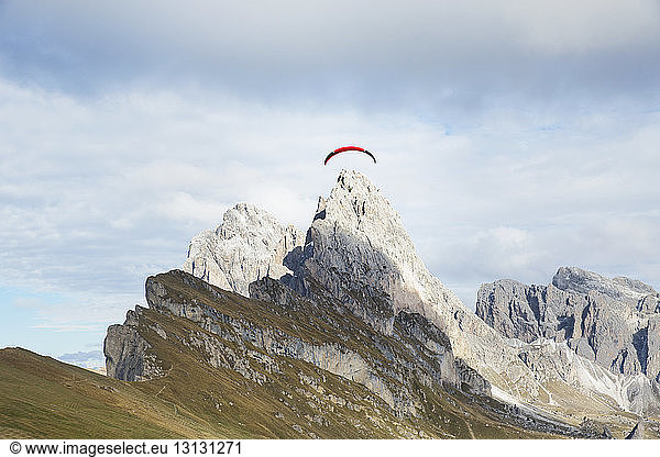Tiefwinkelansicht des Fallschirms über dem Berg gegen bewölkten Himmel