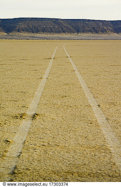 Tire tracks going off into the distance on the desert playa