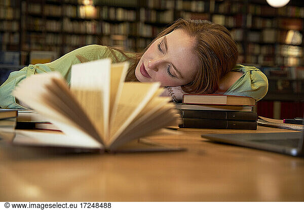 Tired woman sleeping in library