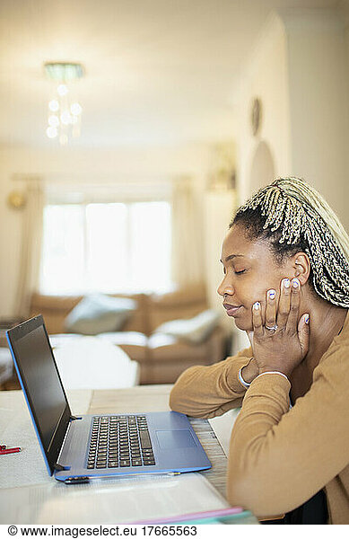 Tired woman working from home at laptop
