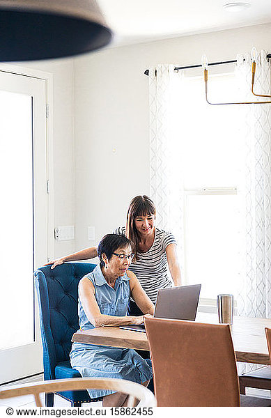 Tochter hilft Mutter mit Computer