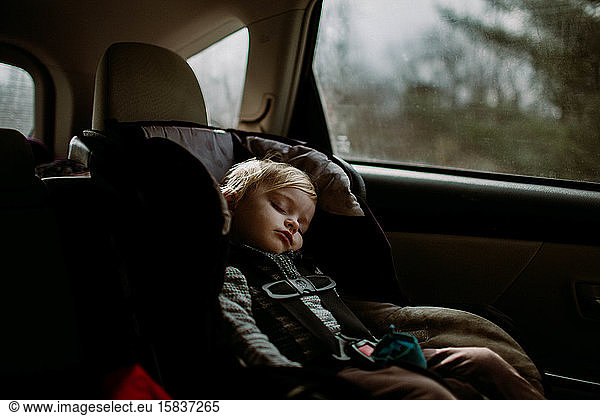 toddler asleep in carseat on road trip