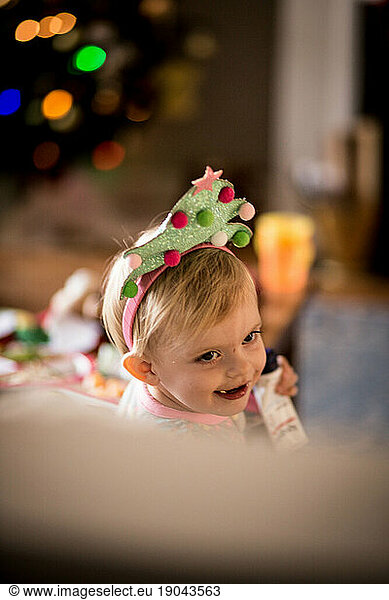 toddler/baby wearing christmas tree headband with bokeh