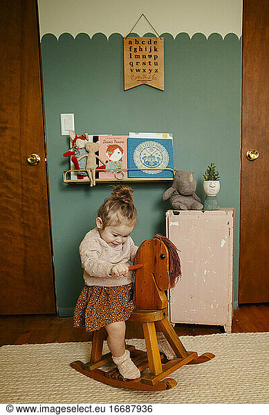 Toddler Girl in Room on rocking horse