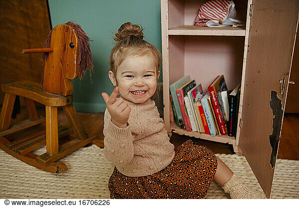 Toddler girl pointing at camera happy
