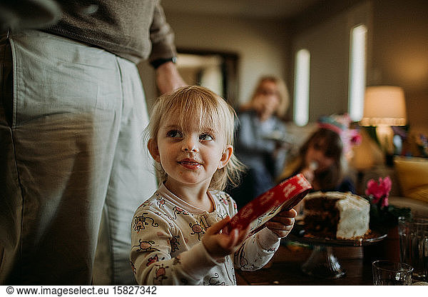toddler in pajamas at family gathering with mischievous smile