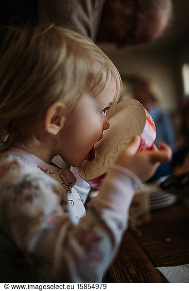 toddler licking the top of ice cream container