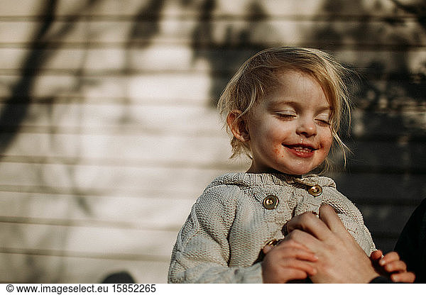 toddler smiling with eeditorial closed in sunlight