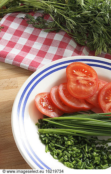 Tomatoes  chives and parsley on a plate  close-up