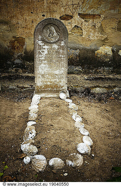 Tombstone and grave lined with abalone shells at The San Carlos BorromÃ¯Â¾Å½o del Rio Carmelo Mission  Carmel  California.